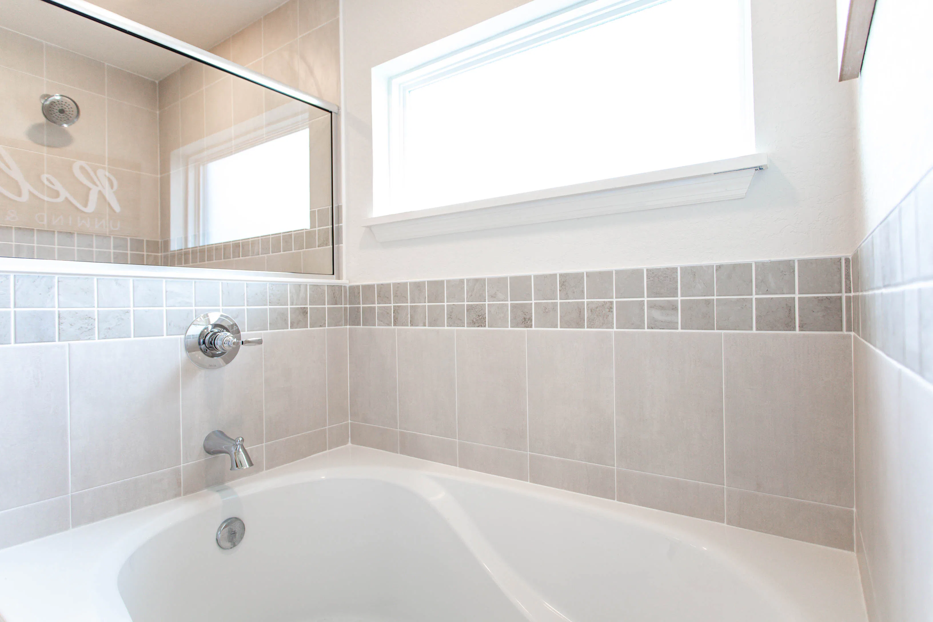 A deep tub with a tiled surround